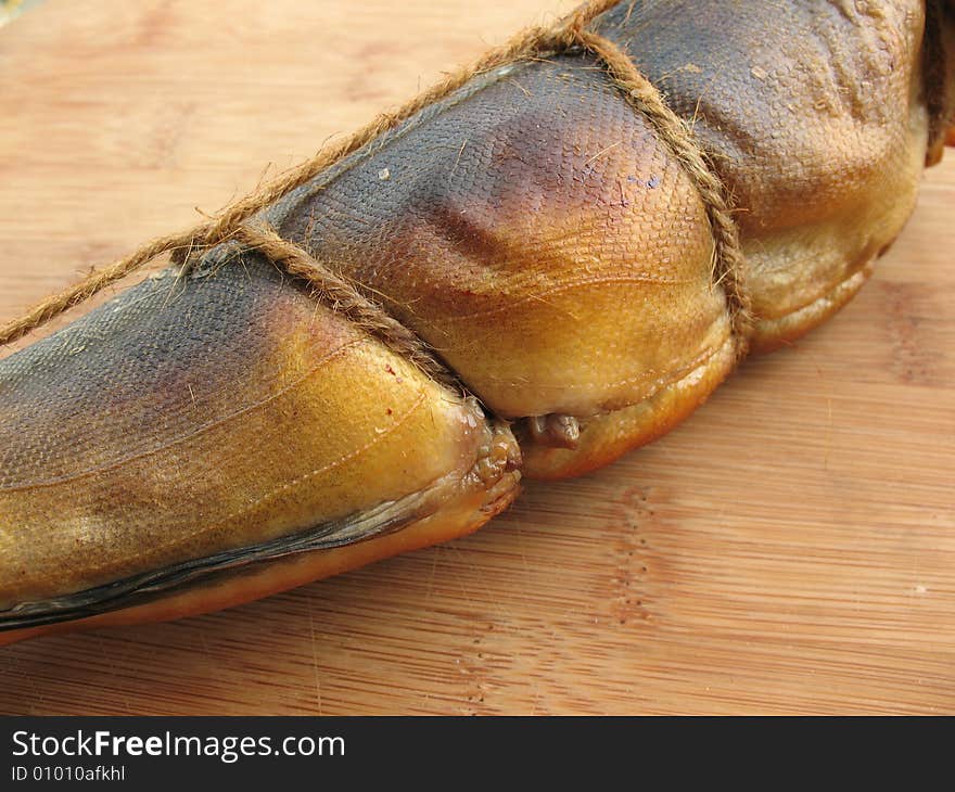 A hot smoked fish on the wooden board