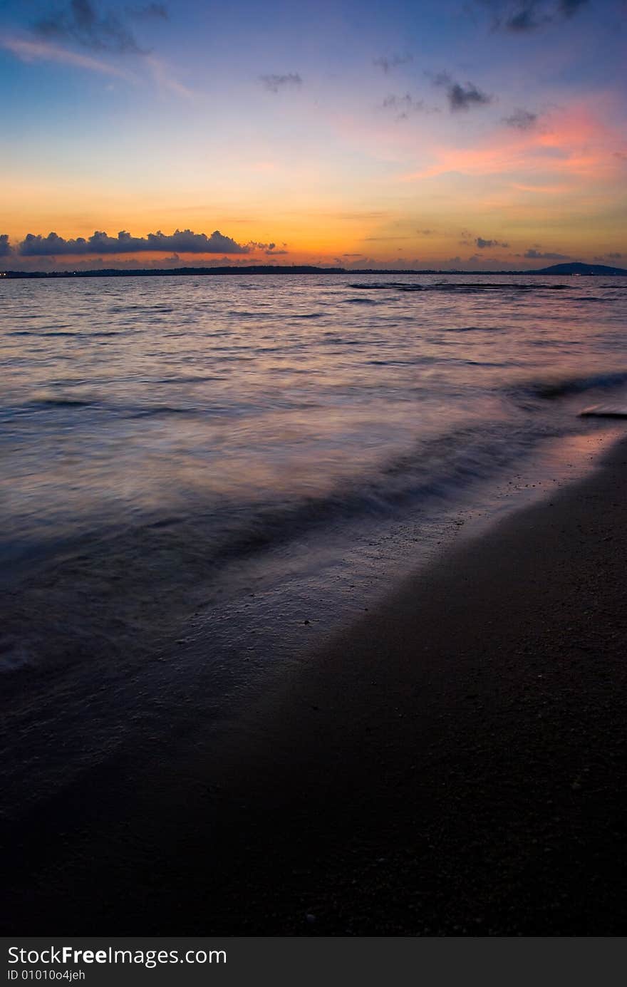 Dawn seen at the beach under a partly cloudy sky. Dawn seen at the beach under a partly cloudy sky