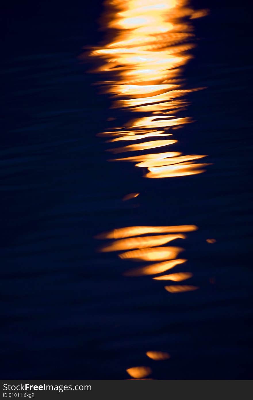 Flamelike reflections of a light in a tranquil lake. Flamelike reflections of a light in a tranquil lake