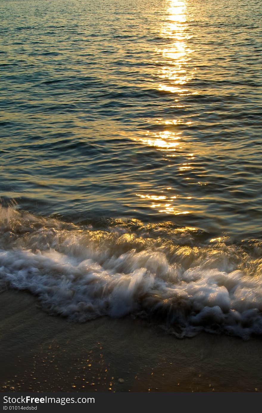 Dawn at the beach with sun reflected in the sea