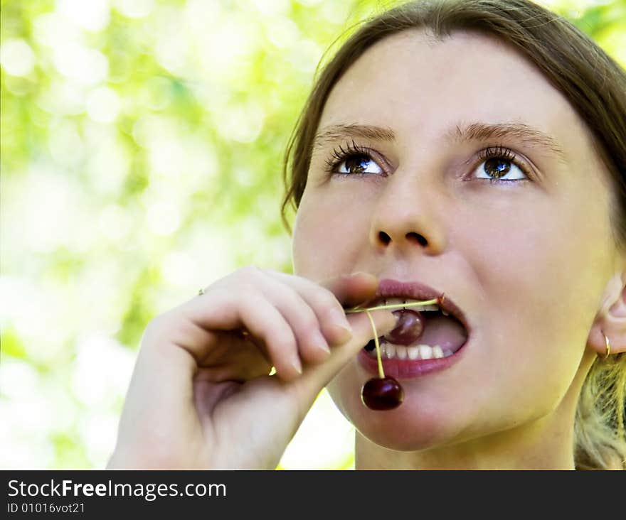 Young woman eating sour cherry