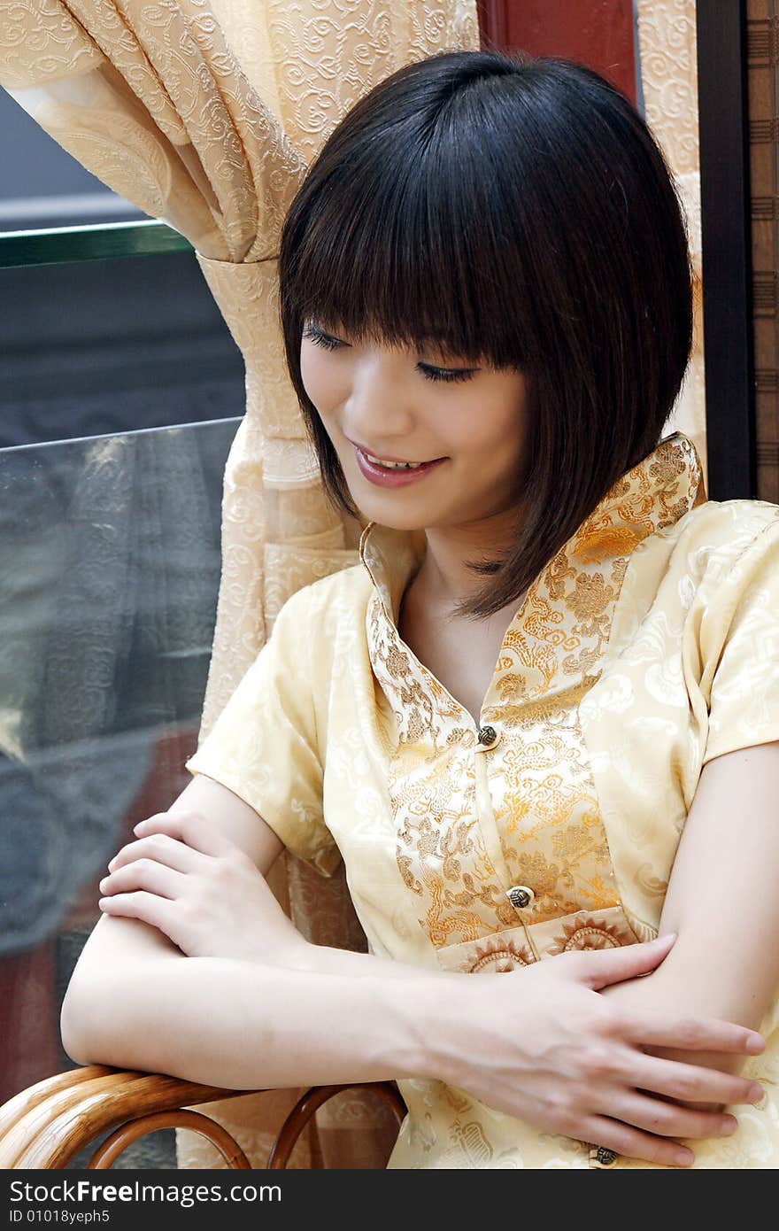 A girl in the ancient tea house of China. She is enjoying the scenery downstairs. A girl in the ancient tea house of China. She is enjoying the scenery downstairs.