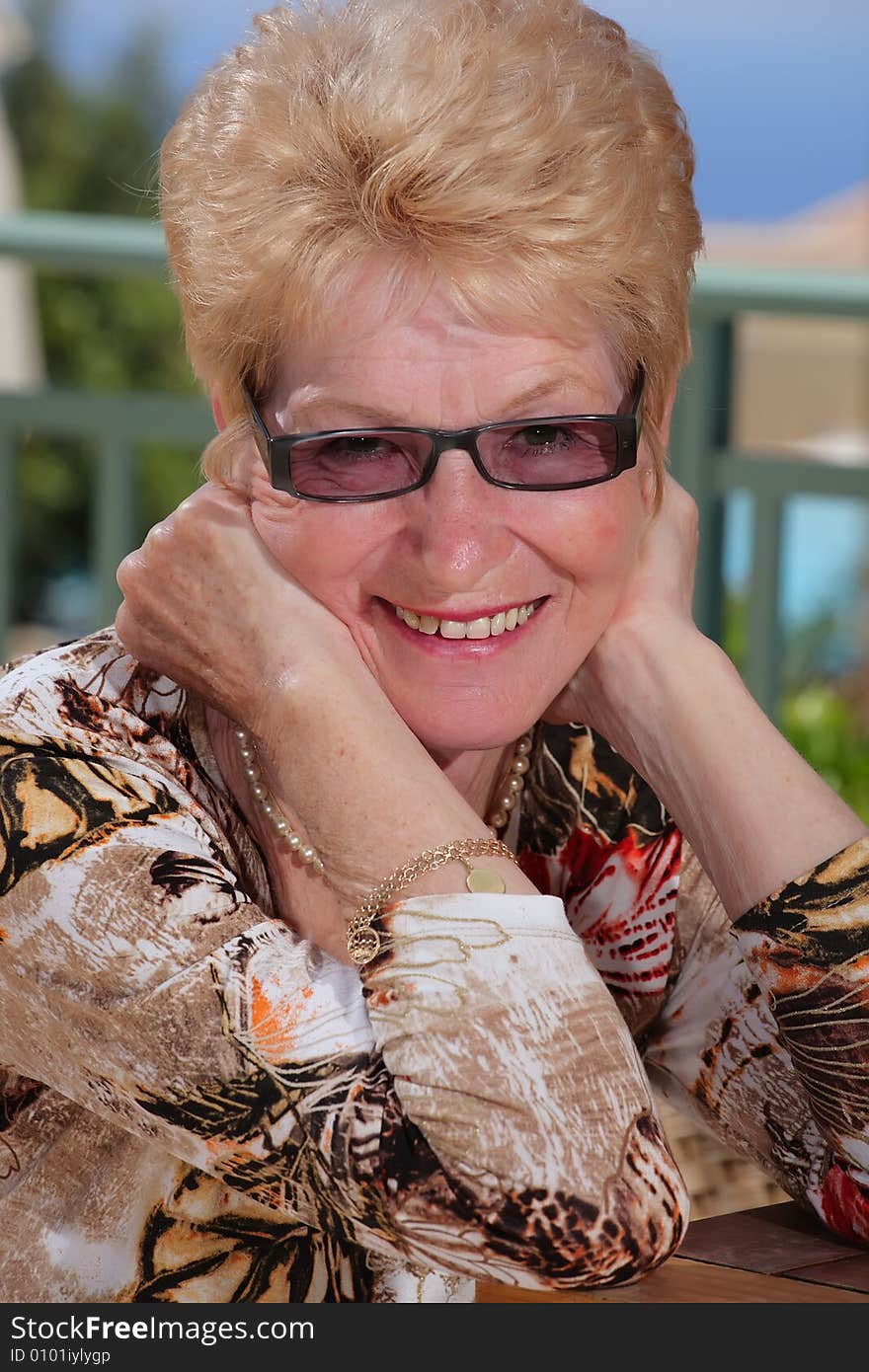 Beautiful smiling senior woman on a balcony. Beautiful smiling senior woman on a balcony