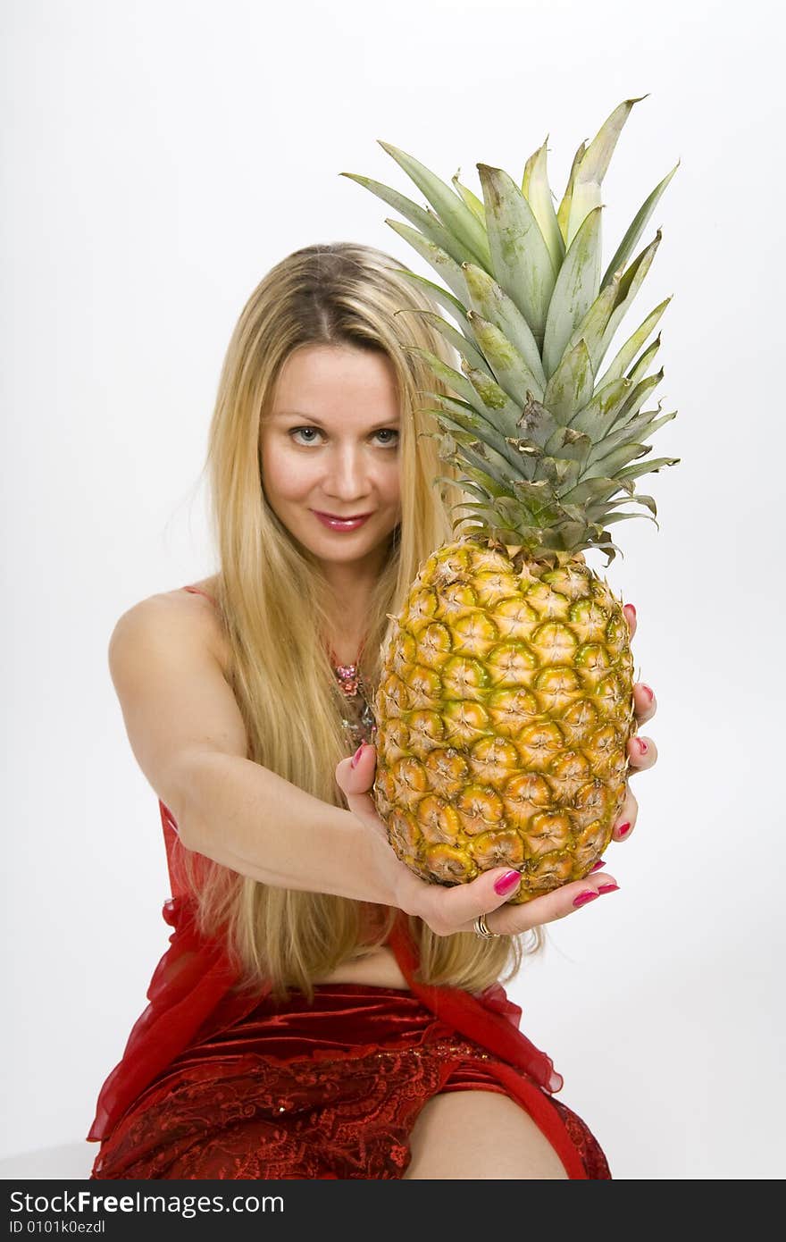 Sitting blonde long hair woman with a pineapple in her hands. Sitting blonde long hair woman with a pineapple in her hands