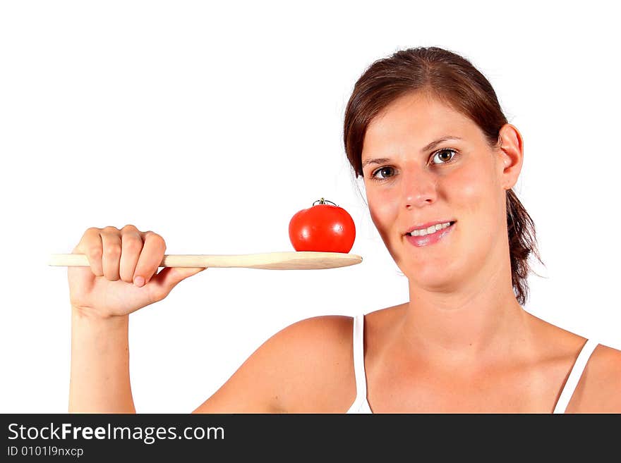 A young happy woman with a tomato and a spoon. Can be used as a cooking / diet shot. A young happy woman with a tomato and a spoon. Can be used as a cooking / diet shot.