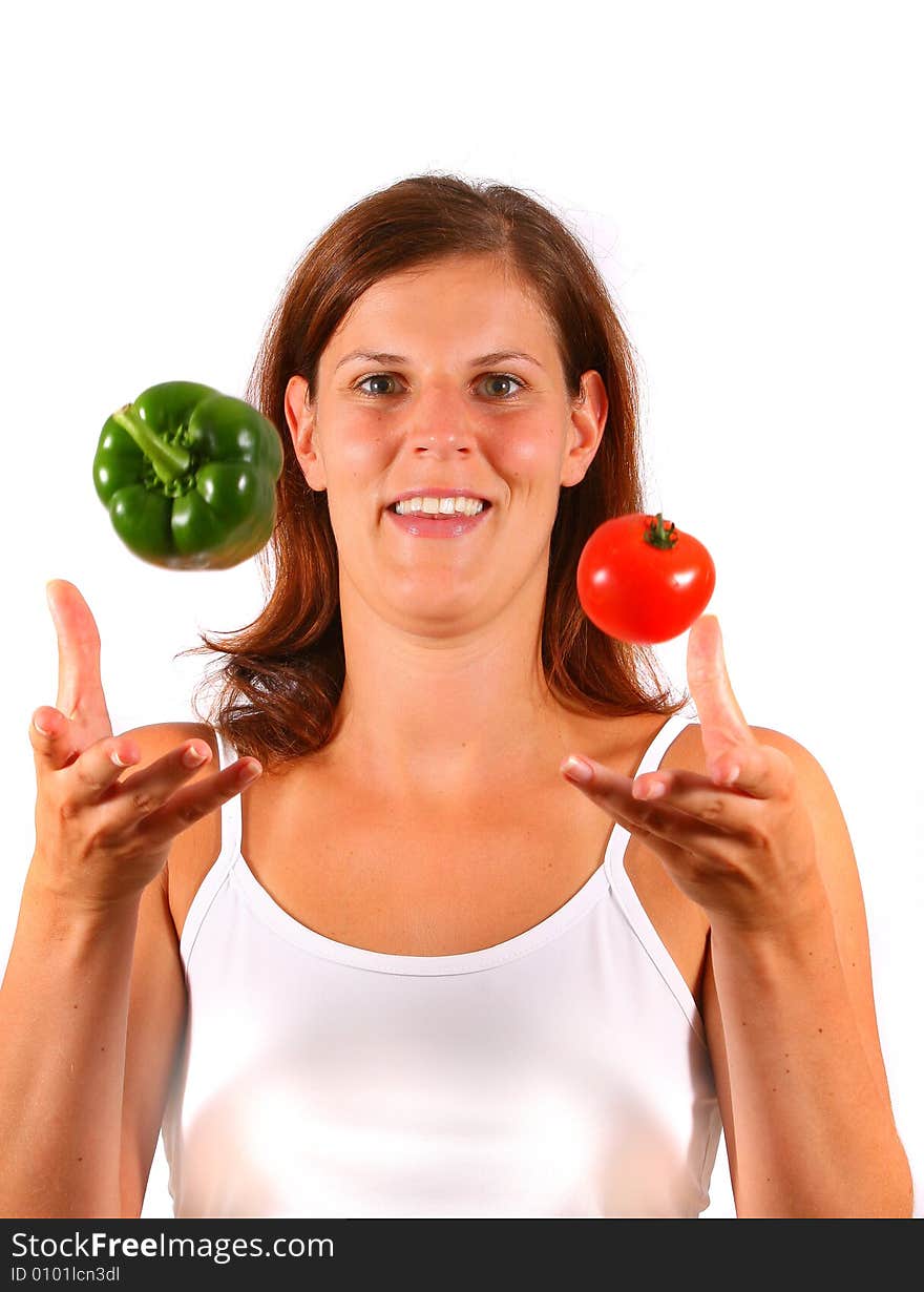 A young happy woman tosses up vegetable. Can be used as a cooking / diet shot. A young happy woman tosses up vegetable. Can be used as a cooking / diet shot.