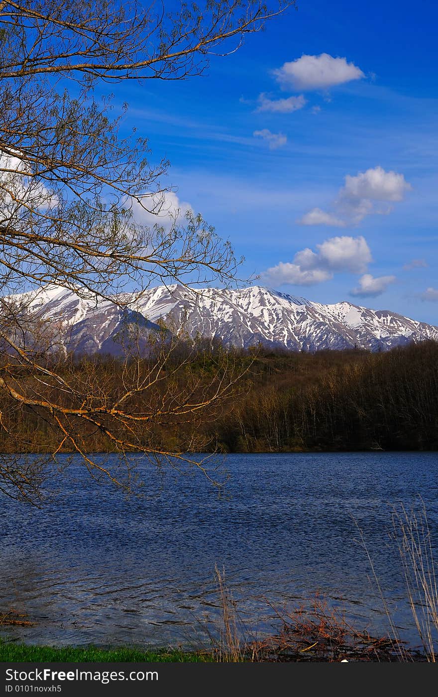 Mountain Lake in  spring with azure sky and some delicate clouds