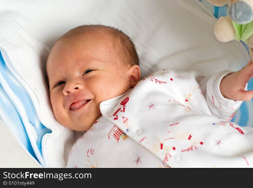 Six week baby lying on diaper. Baby is smiling with wince. Six week baby lying on diaper. Baby is smiling with wince.