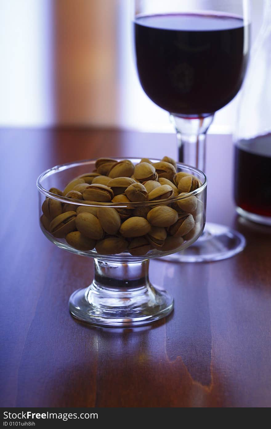 Still life with red wine and pistachios