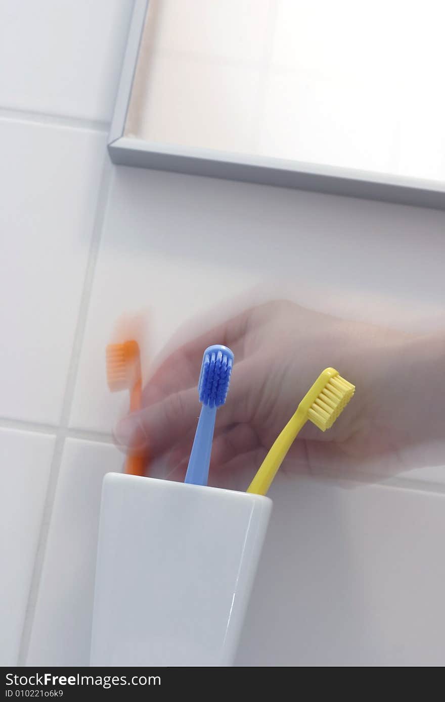 Family's toothbrush in white bathroom