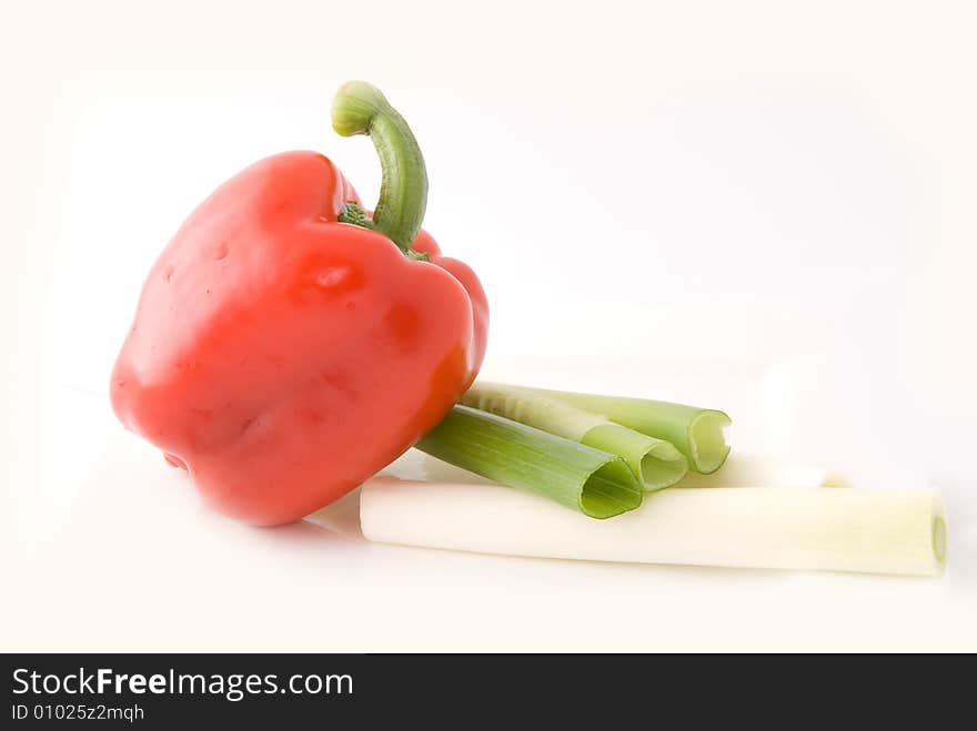 Capsicums and spring onion in lovely colors on white background, shot in studio. Capsicums and spring onion in lovely colors on white background, shot in studio