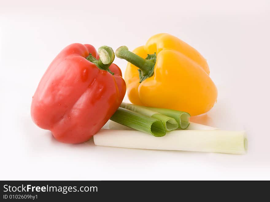 Capsicums and spring onion in lovely colors on white background, shot in studio. Capsicums and spring onion in lovely colors on white background, shot in studio