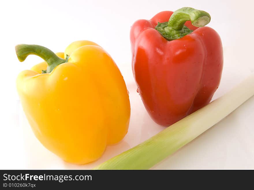 Capsicums and spring onion in lovely colors on white background, shot in studio. Capsicums and spring onion in lovely colors on white background, shot in studio