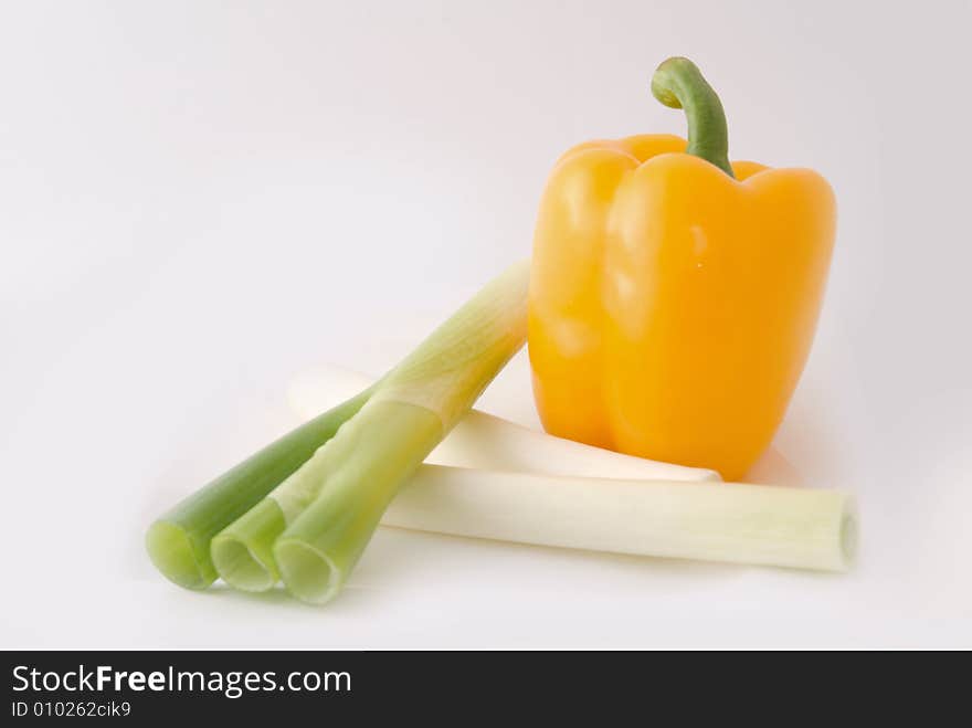 Capsicums and spring onion in lovely colors on white background, shot in studio. Capsicums and spring onion in lovely colors on white background, shot in studio