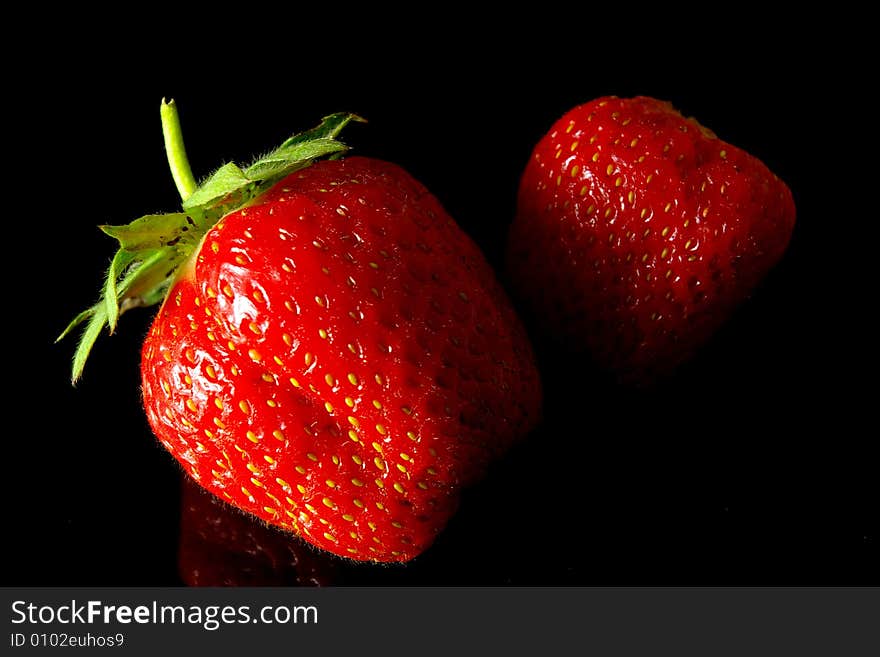 Two strawberries on black