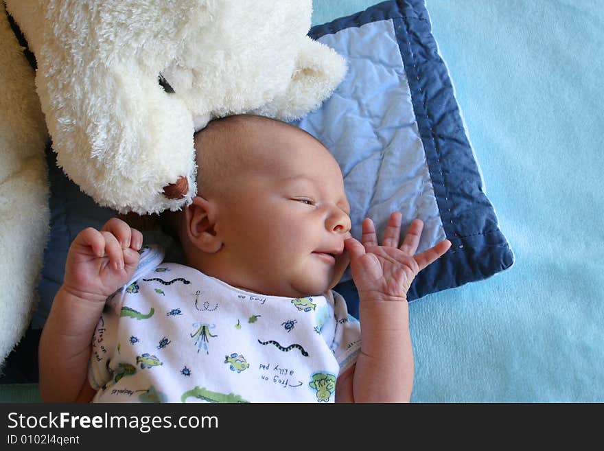 Week old baby boy on a blue blanket early in the morning. Week old baby boy on a blue blanket early in the morning