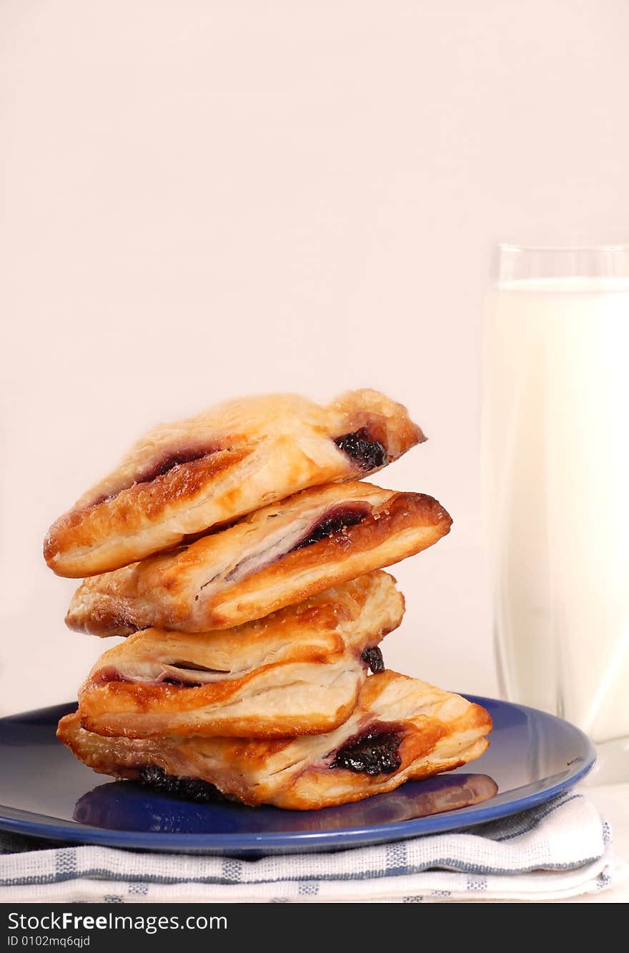 Stack of blueberry turnovers with milk