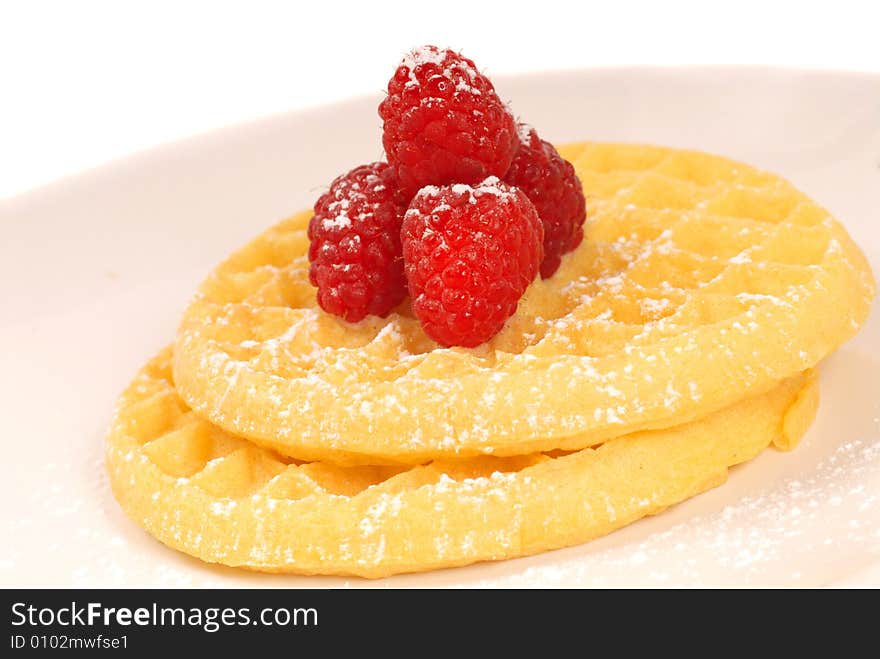 Freshly made waffles with raspberries and powdered sugar. Freshly made waffles with raspberries and powdered sugar