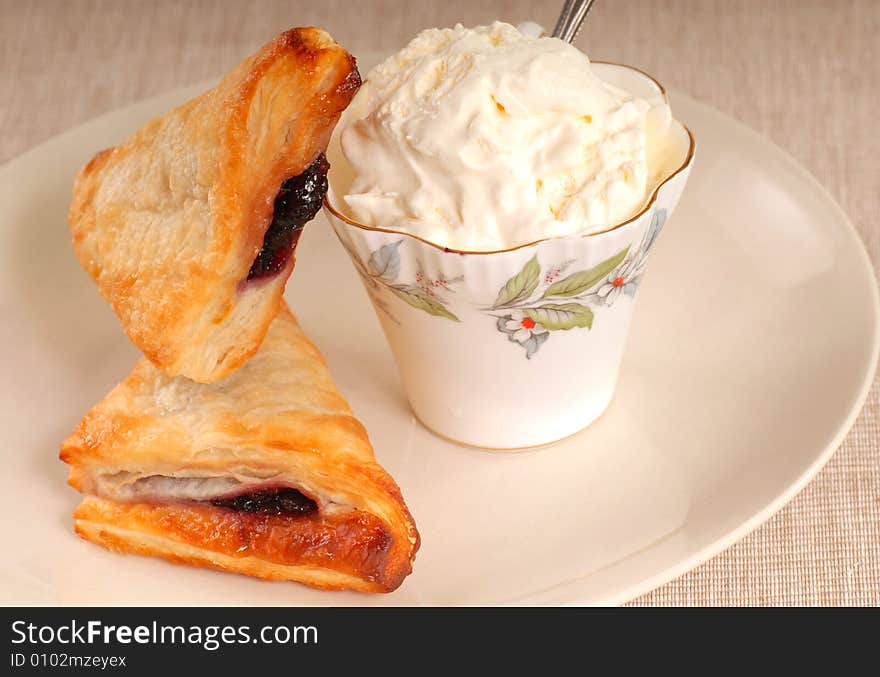 Two blueberry turnovers with fresh whipped cream