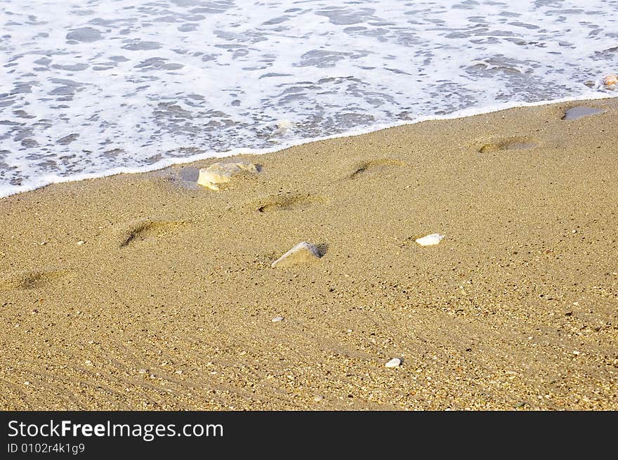 Foot print along the coastline, waves crashin up. Foot print along the coastline, waves crashin up