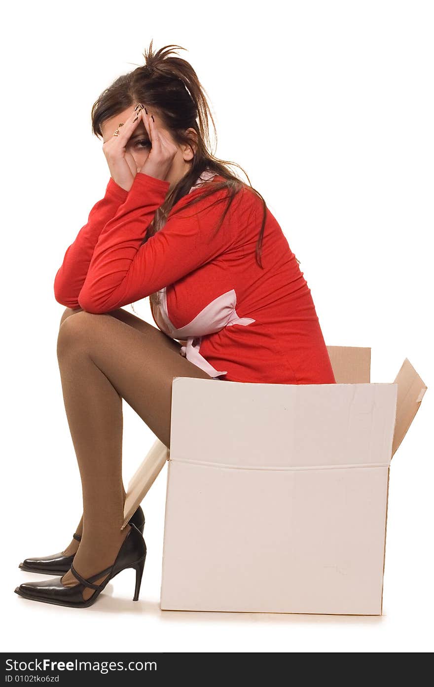 Young woman dressed in red clothes sitting on cardboard box