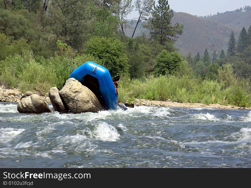 River rafters miss the channel and get hung up on boulders rafting down the American river. River rafters miss the channel and get hung up on boulders rafting down the American river