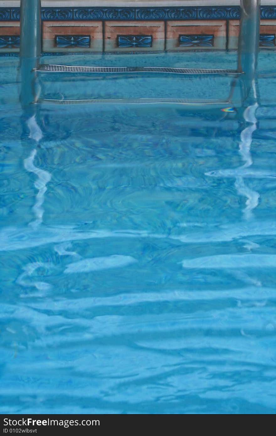 Blue Water and Swimming Pool Steps are Featured in an Abstract Image.