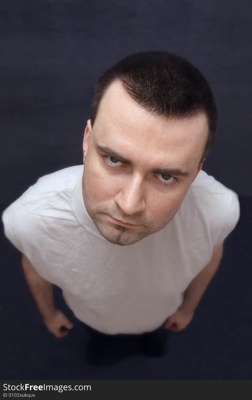 Serious young man staring into camera upwards