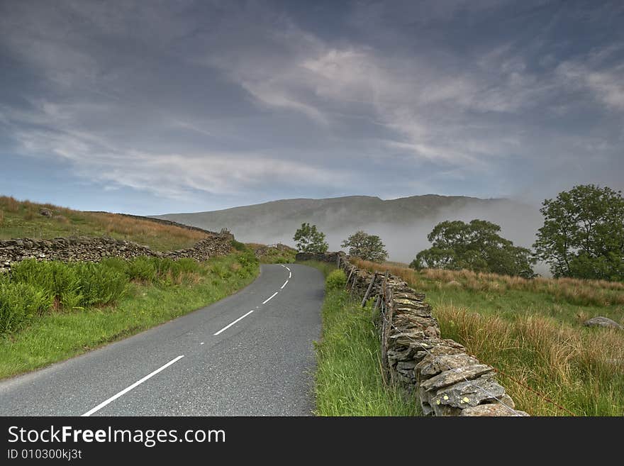 The Kirkstone Pass road in the English Lake District, A bank of fog can be seen in the distance