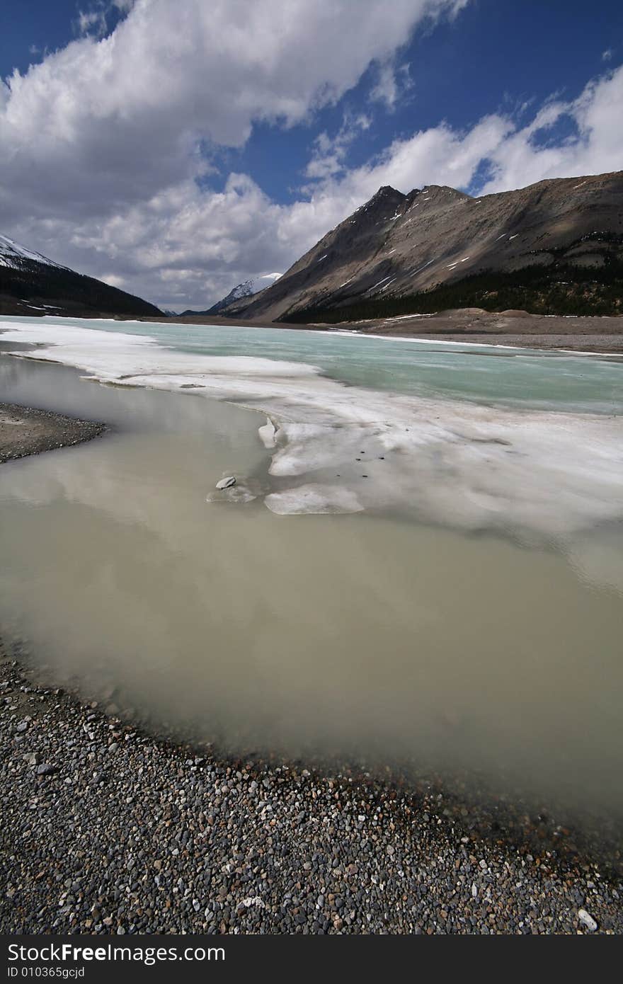 Dirty water separated from a clear lake by melting ice. Dirty water separated from a clear lake by melting ice.