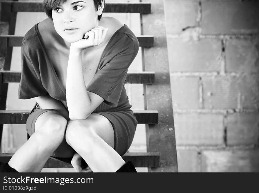 Thoughtful young woman on metal stairs