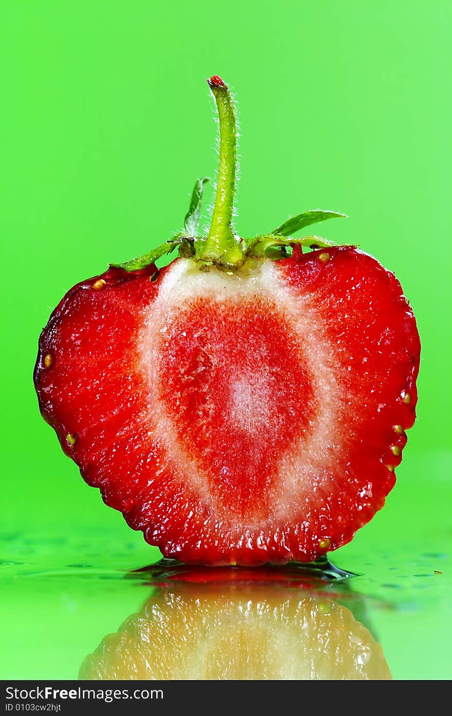 Slice of a strawberry on green background