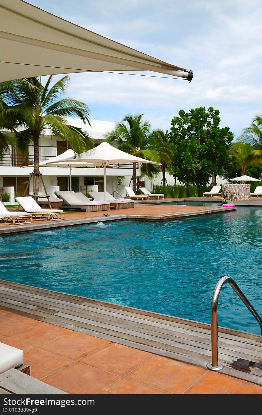 White trestle-beds and umbrellas near the resort's pool. White trestle-beds and umbrellas near the resort's pool