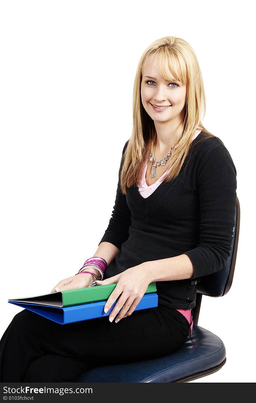 Beautiful blonde businesswoman holding green and blue files while sitting on a blue office chair. Isolated on white background. Beautiful blonde businesswoman holding green and blue files while sitting on a blue office chair. Isolated on white background