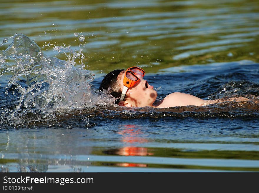 The fast swimming boy in a lake late afternoon. The fast swimming boy in a lake late afternoon.