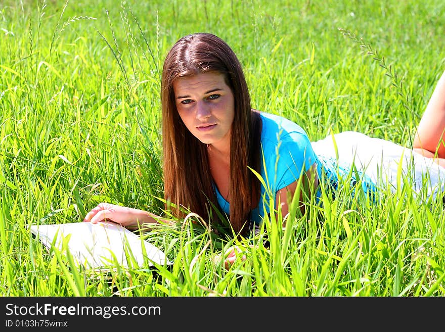 Young woman on the meadow in the summer reading a book. Young woman on the meadow in the summer reading a book.