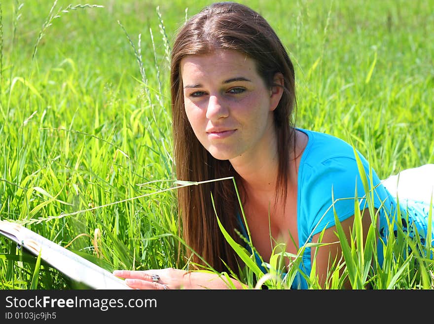 Young woman on the meadow in the summer reading a book. Young woman on the meadow in the summer reading a book.