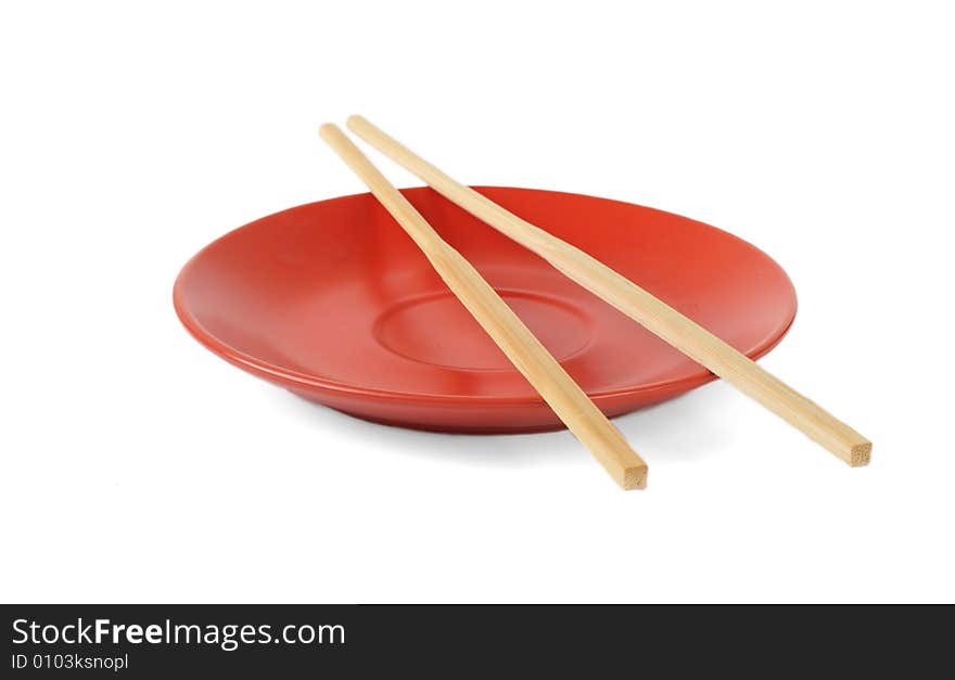 Red plate with bamboo chopsticks isolated on white background