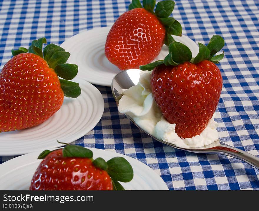 Delicious fresh strawberries with blue gingham tablecloth