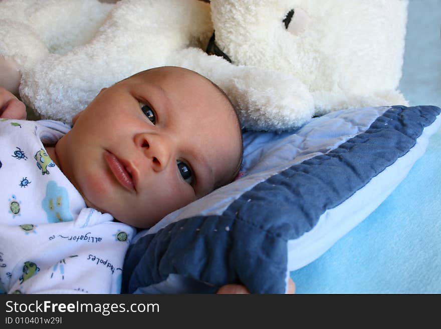 Week old baby boy on a blue blanket early in the morning. Week old baby boy on a blue blanket early in the morning