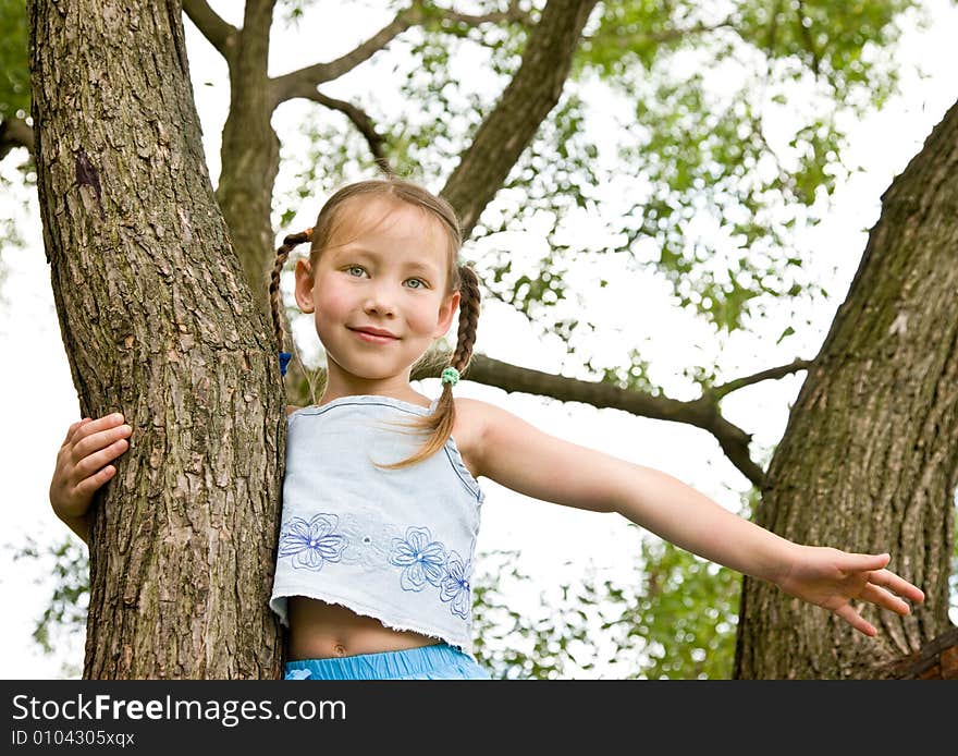 Cheerful girl on a tree