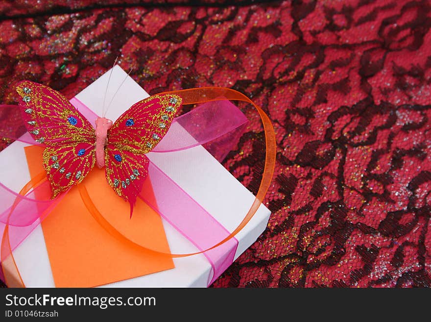 Pink butterfly on a white gift box as a decoration. Pink butterfly on a white gift box as a decoration