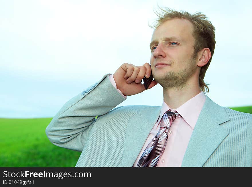 Businessman in field with cellphone