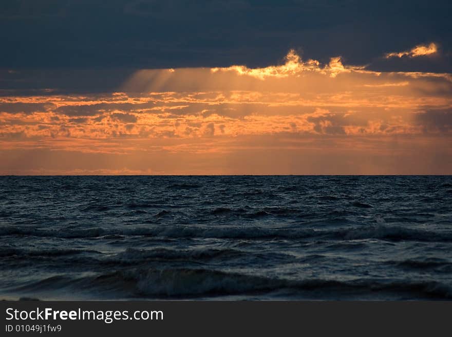 The sea, solar beams, clouds