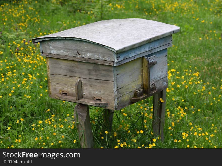 Rural wood bee hive on meadow with bright flowers. Rural wood bee hive on meadow with bright flowers