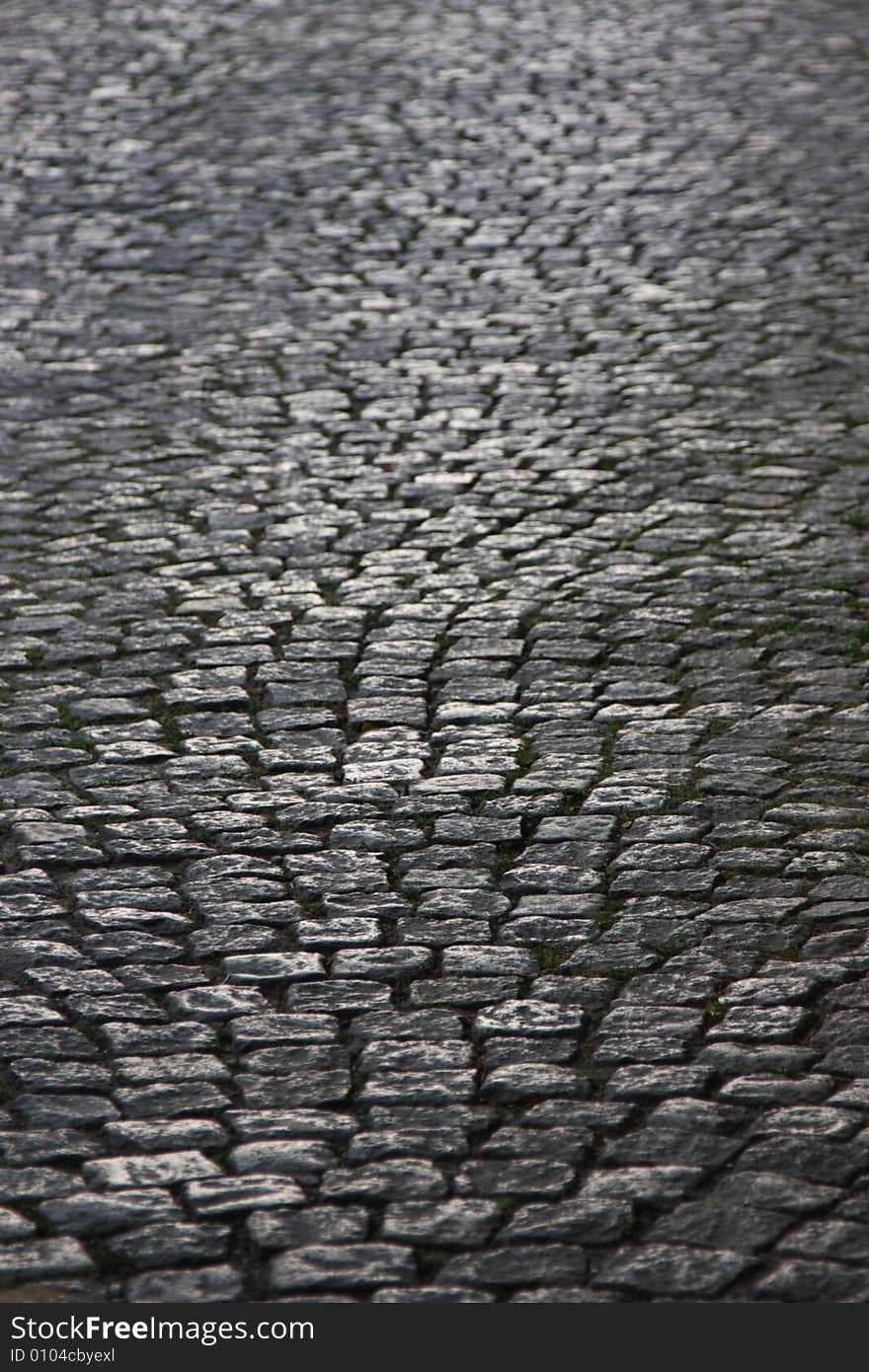 Abstract medieval granite cobble road lit by evening sun. Abstract medieval granite cobble road lit by evening sun