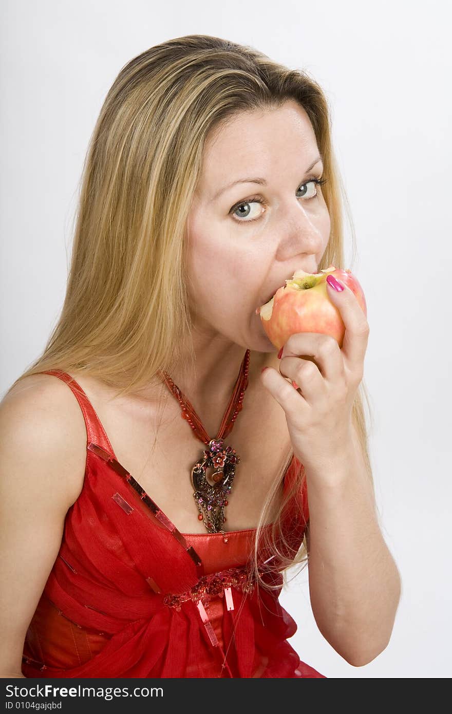 Long hair blonde woman in red with apple in her mouth. Long hair blonde woman in red with apple in her mouth