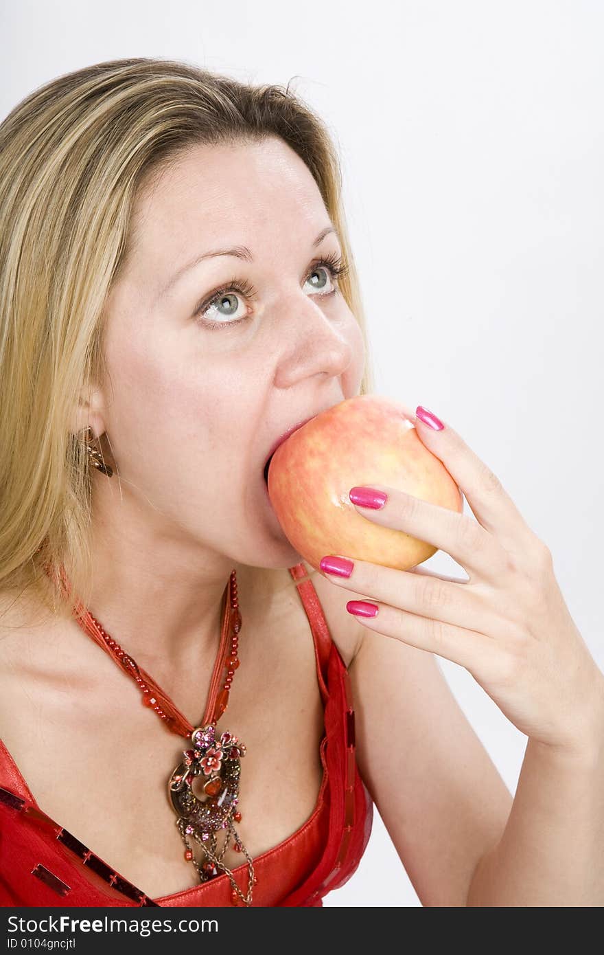 Long hair blonde woman in red with  apple in her mouth. Long hair blonde woman in red with  apple in her mouth