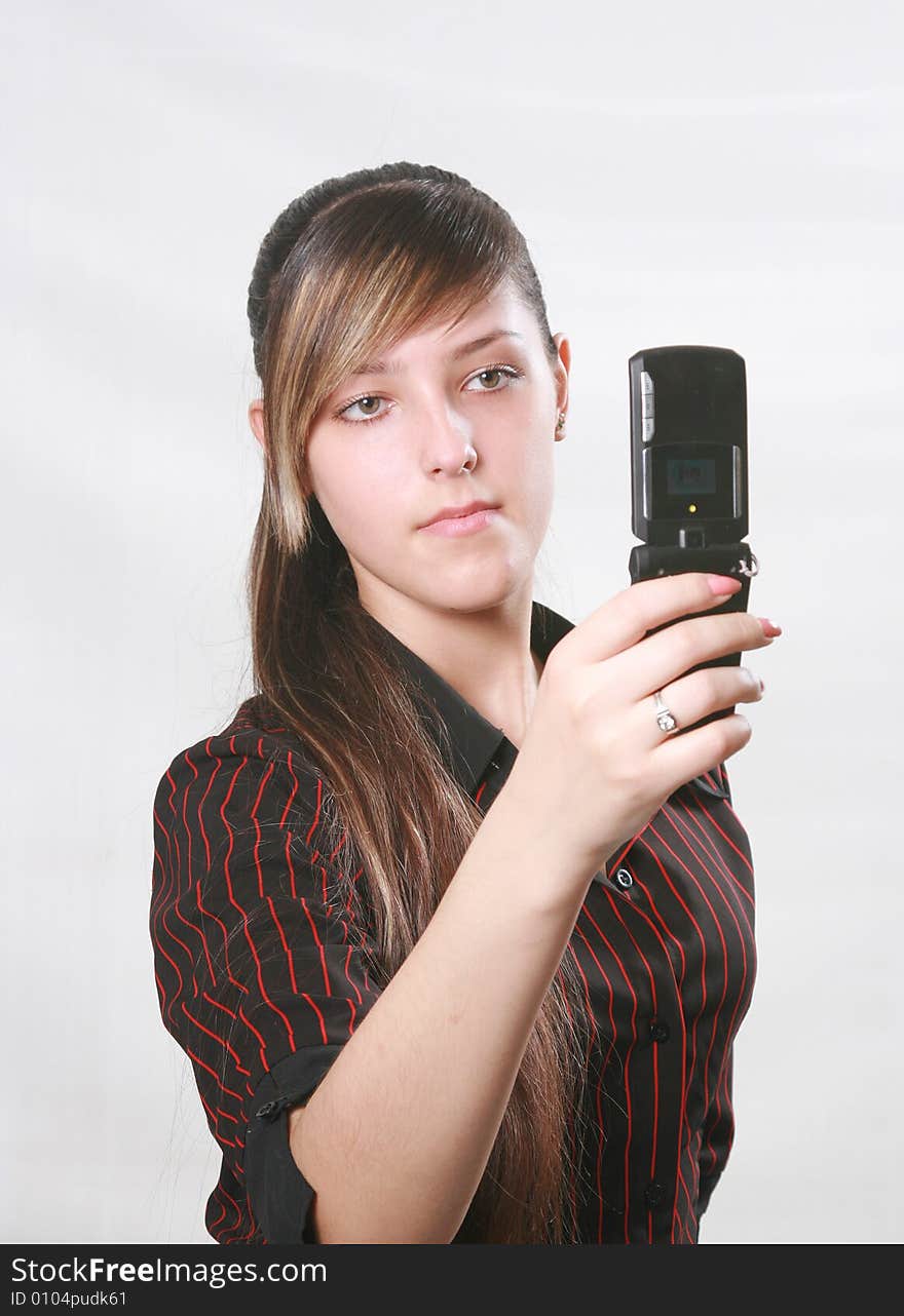 The beautiful girl holds a mobile phone and prints the message