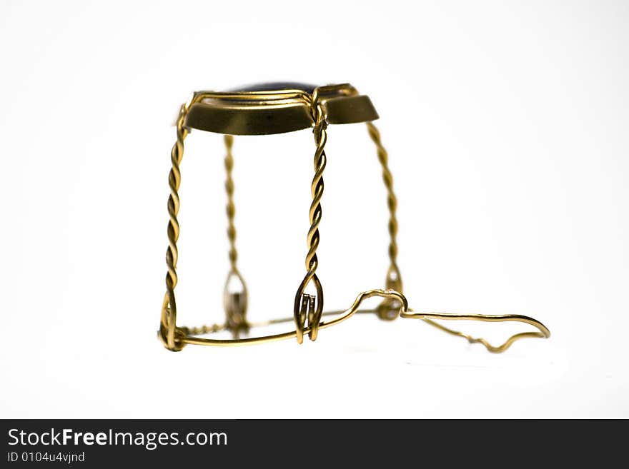 A gold champagne wire cap on an pure white background.